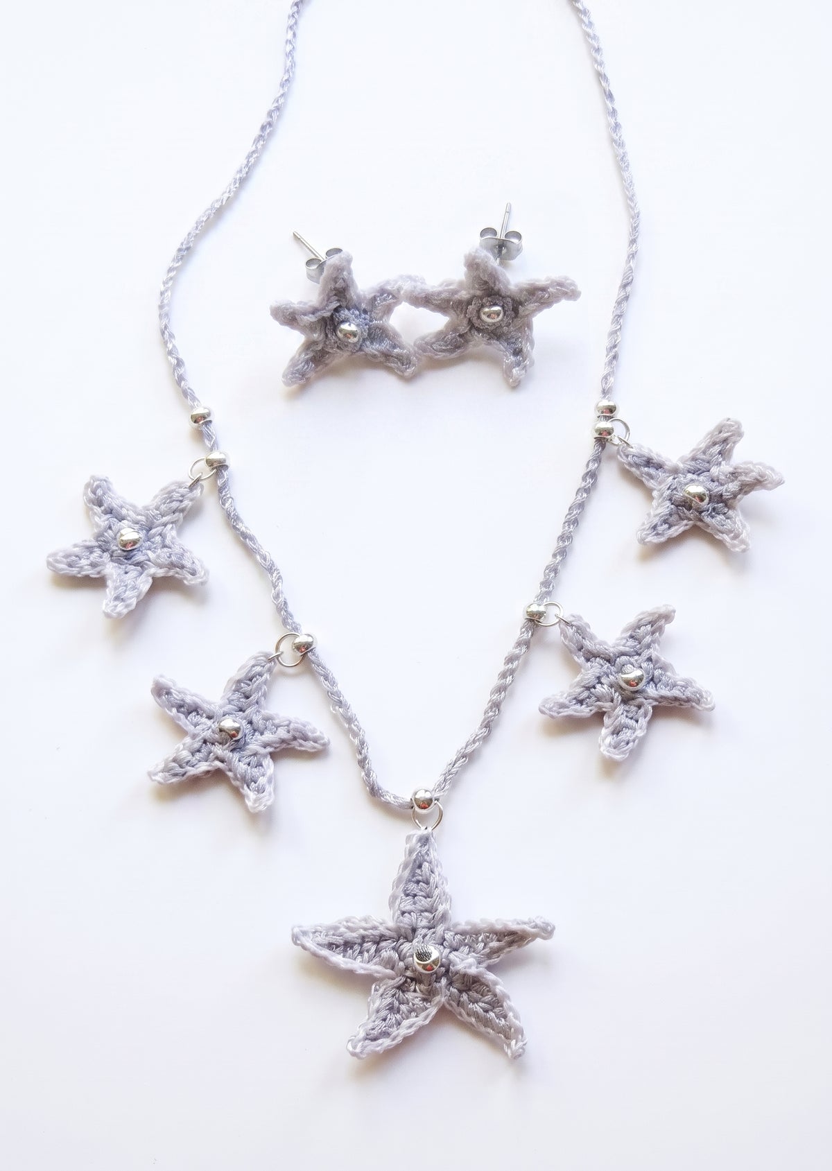 Conjunto de collar y pendientes de crochet con forma de estrellas de mar plateadas.
